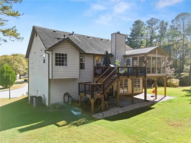 a view of a house with backyard and trees