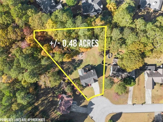 an aerial view of residential houses with outdoor space and trees