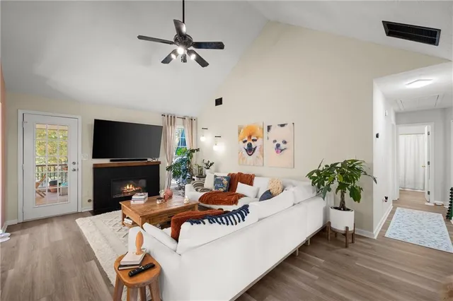 a living room with furniture a flat screen tv and a fireplace