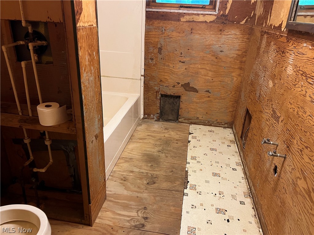 4681 Irish Run Road Southeast Dennison, OH 44621 - Photo 10 of 10 Bathroom featuring wood walls, hardwood / wood-style flooring, and toilet