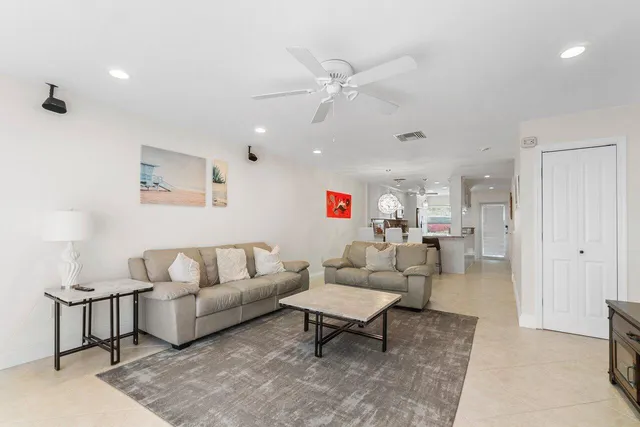 a living room with furniture and a view of kitchen