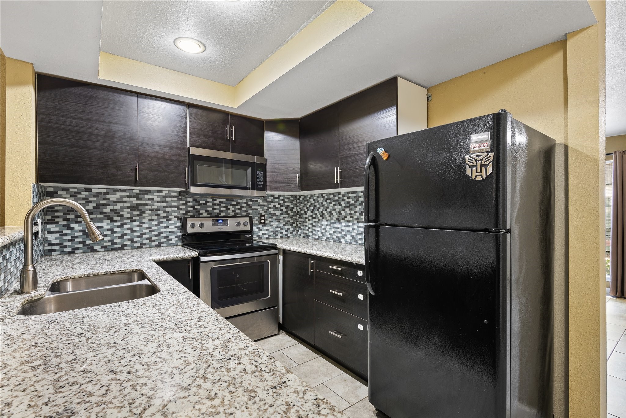 1425 Springrock Lane Houston, TX 77055 - Photo 8 of 30 a kitchen with stainless steel appliances kitchen island granite countertop a refrigerator and a sink