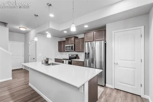 a kitchen with kitchen island a sink appliances and cabinets