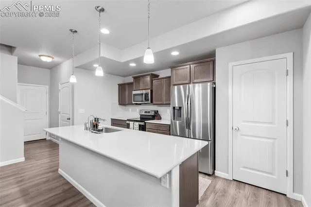 a kitchen with kitchen island a sink appliances and cabinets