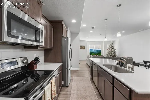 a kitchen with kitchen island granite countertop a sink stove and cabinets