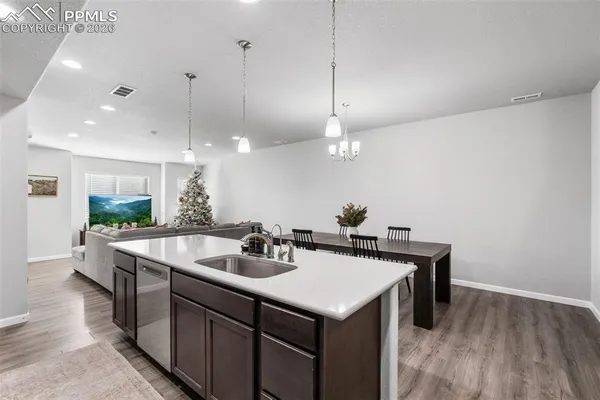 a kitchen with a sink a counter space appliances and cabinets