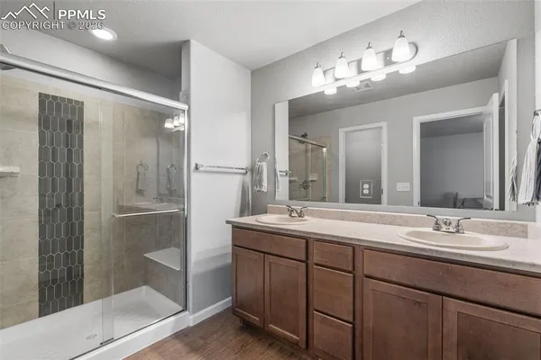 a bathroom with a double vanity sink mirror and shower