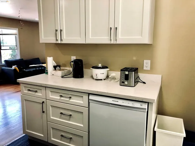 a kitchen with white cabinets and sink