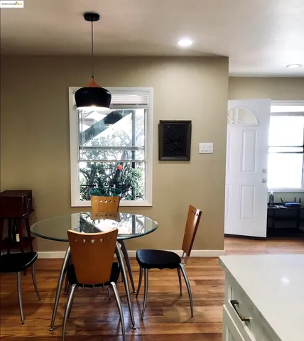 a dining room with furniture a chandelier and wooden floor