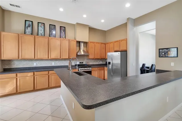 a kitchen with stainless steel appliances granite countertop a sink a stove top oven a counter space and cabinets