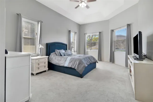 a spacious bedroom with a bed and a flat screen tv