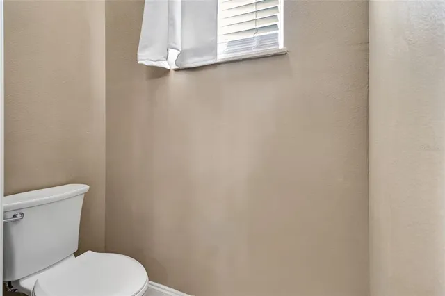 a white toilet sitting next to a window
