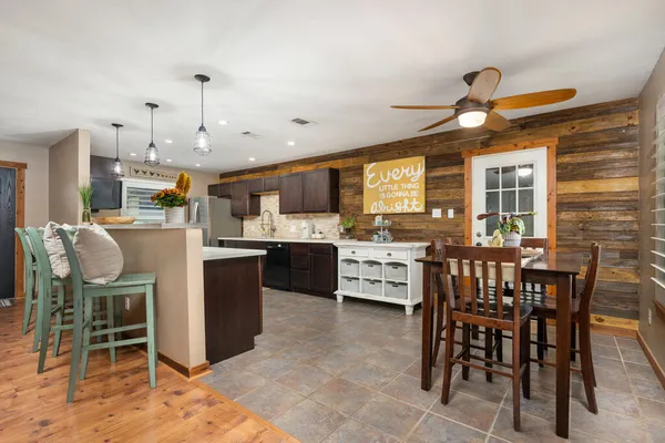 a kitchen with kitchen island a dining table and chairs