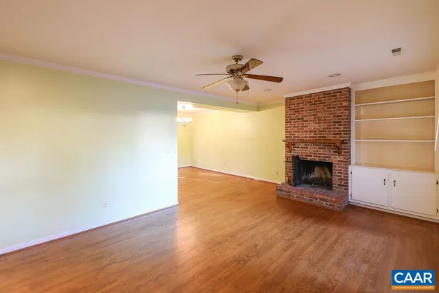 a view of empty room with wooden floor and fireplace