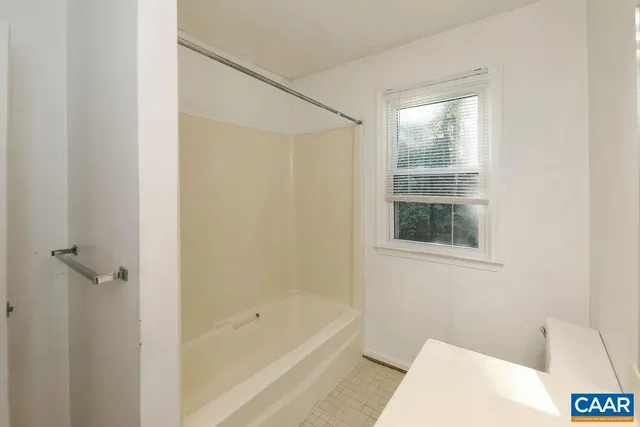 a view of a big room with windows and chandelier fan