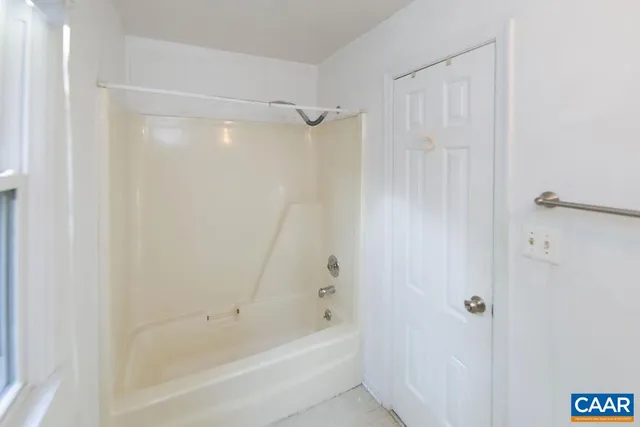 a view of a wooden house with a yard and large tree