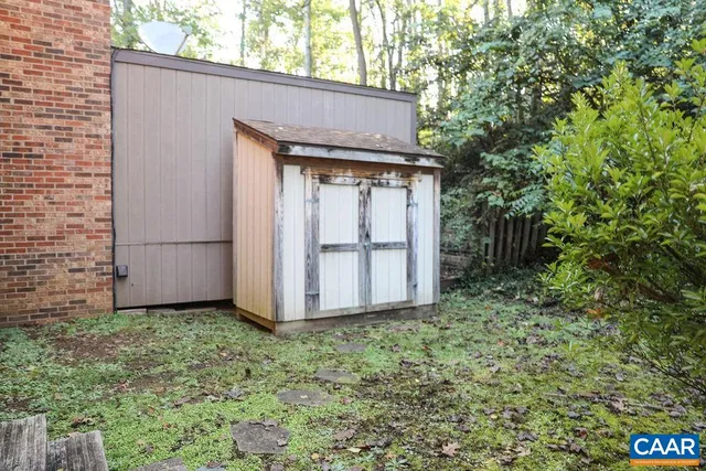 a view of a brick house with a yard and a large tree