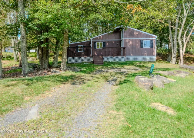 a view of a house with a yard and deck
