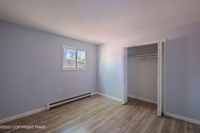 a view of a hallway with wooden floor and a window