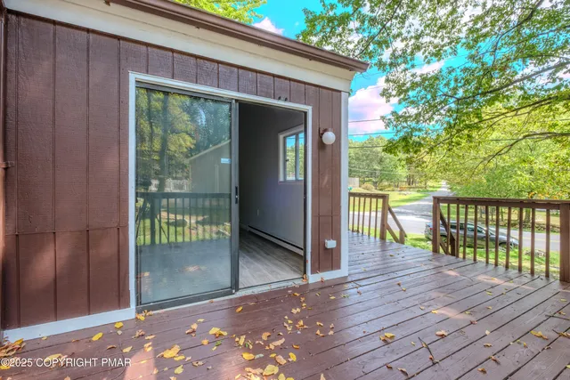 a view of backyard with large tree and wooden fence