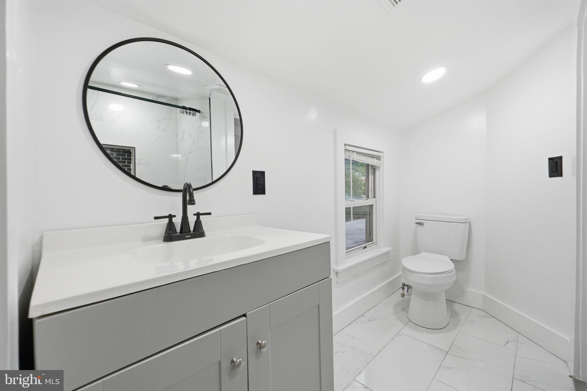 5906 Berwyn Road College Park, MD 20740 - Photo 16 of 46 a bathroom with a toilet a sink and a mirror