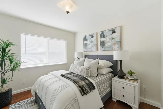 a bedroom with a bed and a potted plant