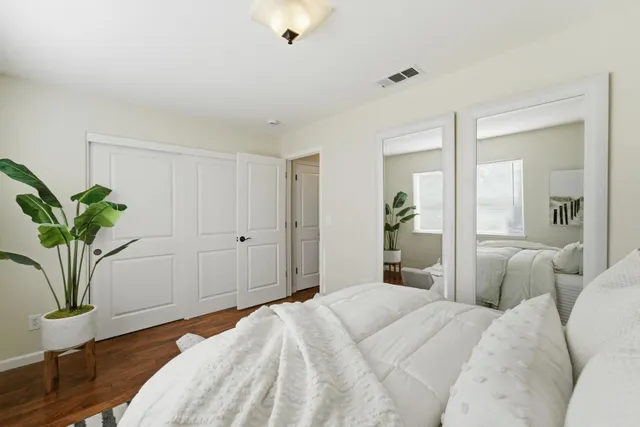 a bedroom with a bed and a potted plant