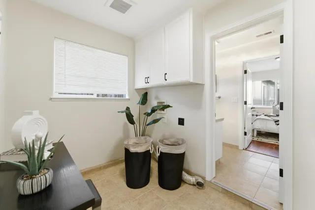 a living room with furniture a window and a potted plant