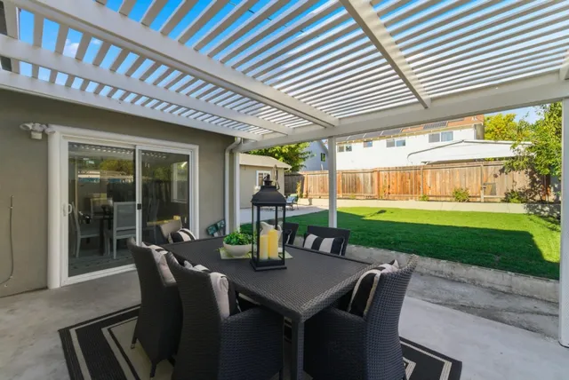 a view of a patio with a table chairs and a backyard