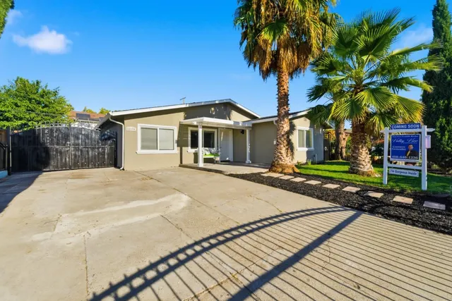 a front view of a house with a yard and potted plants