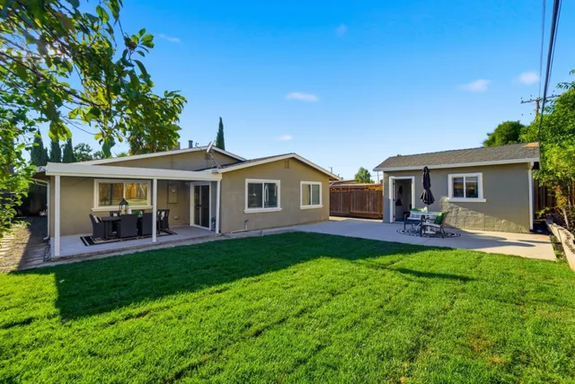a front view of a house with a yard and patio