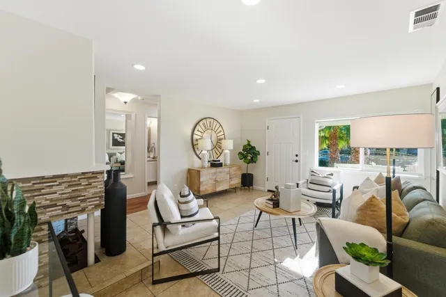 a living room with furniture a fireplace and a large window
