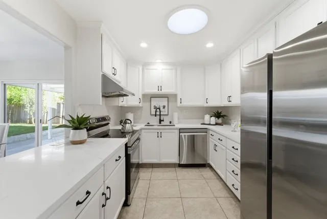 a kitchen with kitchen island granite countertop a sink counter top space appliances and cabinets