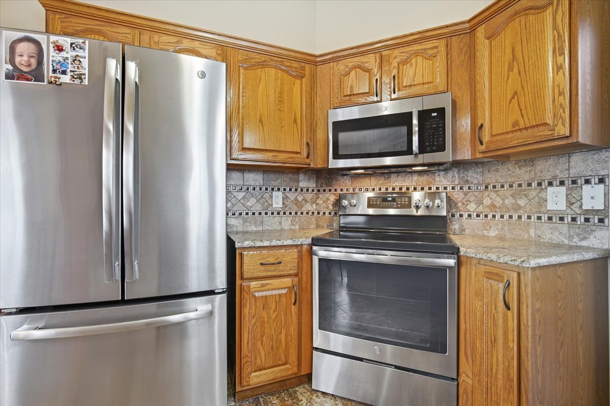 9 Spruce Court Bloomington, IL 61704 - Photo 13 of 42 a kitchen with stainless steel appliances granite countertop a refrigerator stove and microwave