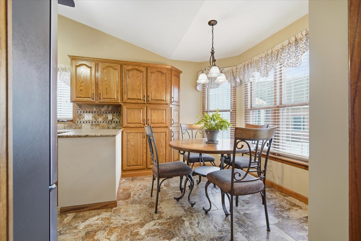 9 Spruce Court Bloomington, IL 61704 - Photo 16 of 42 a dining room with furniture a chandelier and kitchen view