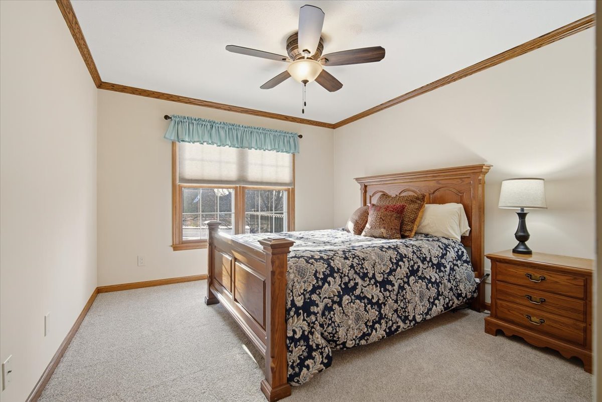 9 Spruce Court Bloomington, IL 61704 - Photo 22 of 42 a bedroom with a bed and a ceiling fan with a large window