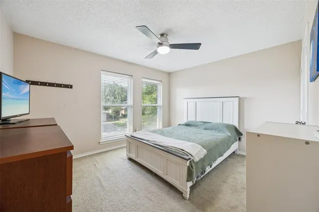 a spacious bedroom with a bed and a flat screen tv