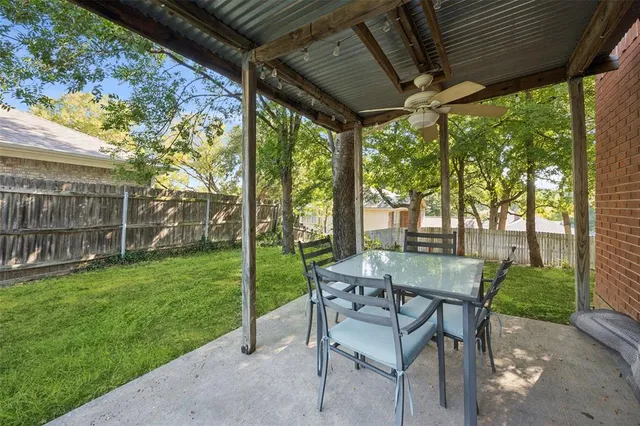 a view of a patio with a table chairs and a backyard