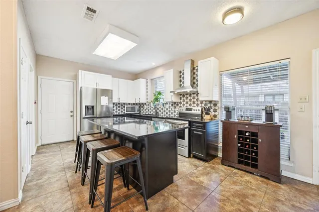 a kitchen with a table chairs refrigerator and window