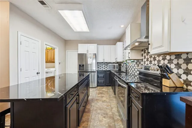 a kitchen with granite countertop lots of counter top space and stainless steel appliances