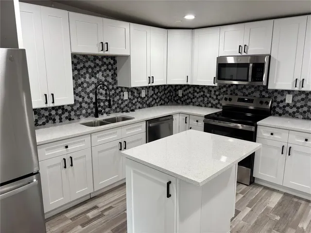 a kitchen with white cabinets and stainless steel appliances