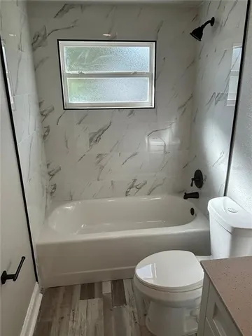 a white toilet sitting next to a bath tub