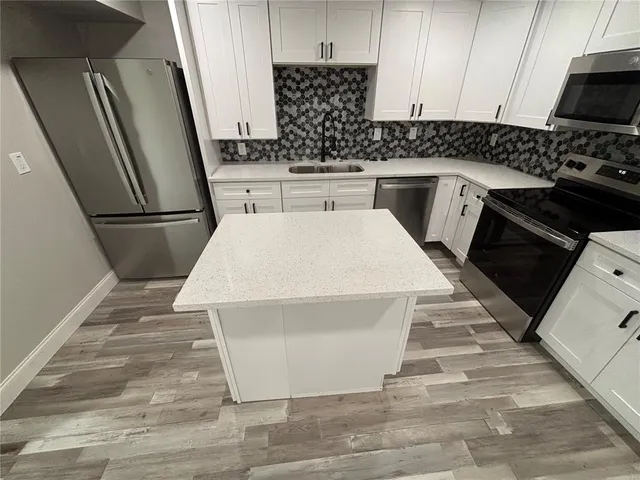 a kitchen with stainless steel appliances a refrigerator sink and stove