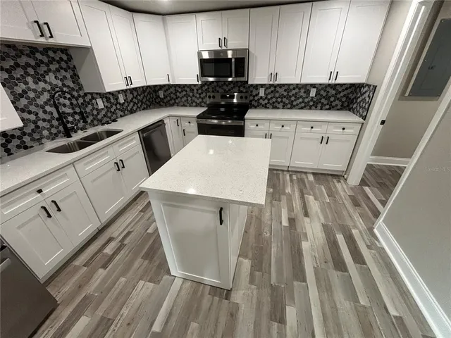 a kitchen with white cabinets sink and stainless steel appliances
