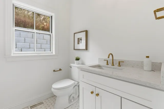 a bathroom with a granite countertop toilet sink and mirror