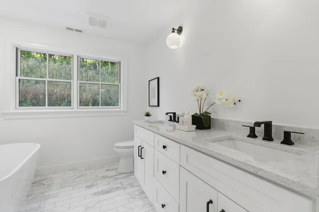 a white bath tub sitting next to a shower