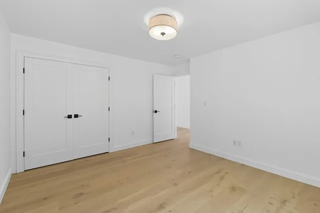 a view of an empty room with a window and closet area