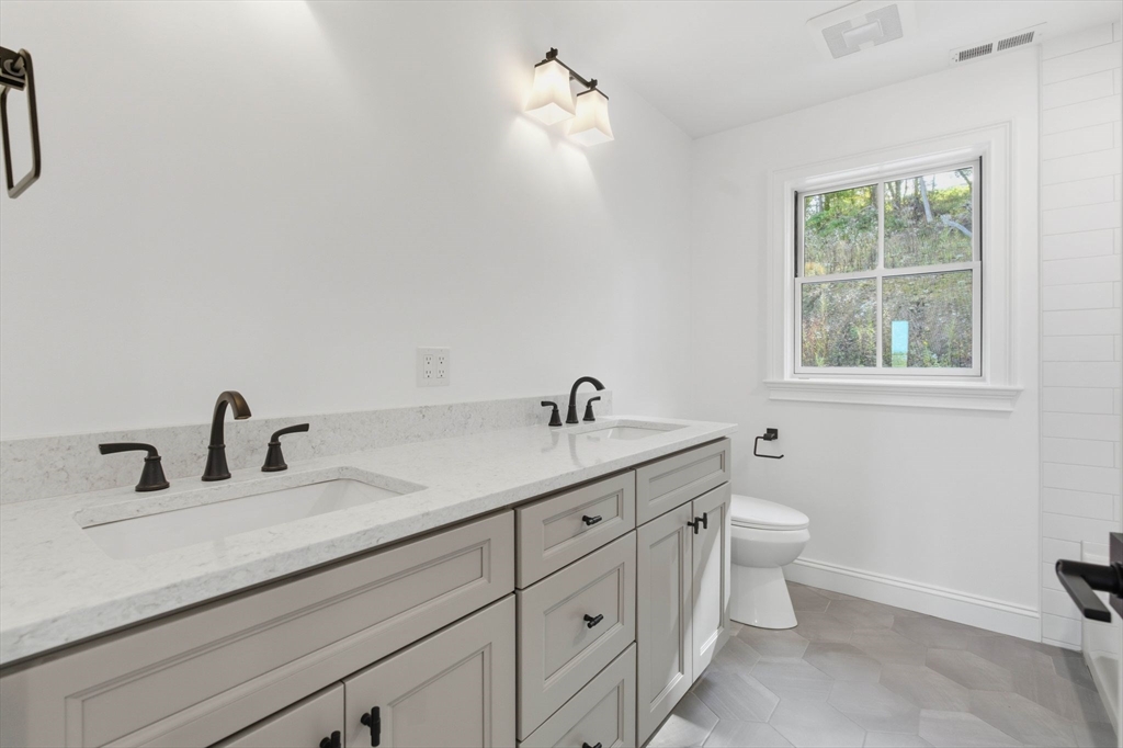 161 Bridge Street Hamilton, MA 01982 - Photo 34 of 42 a bathroom with a double vanity sink a toilet and a window