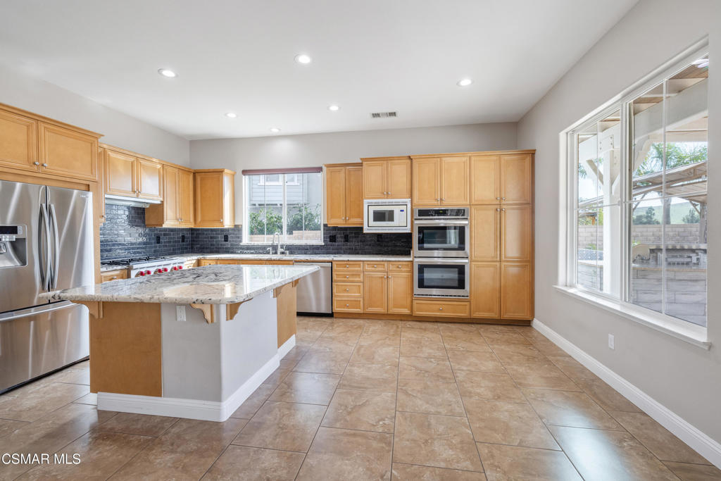 4920 Corral Street Simi Valley, CA 93063 - Photo 12 of 54 a kitchen with stainless steel appliances granite countertop a stove top oven a refrigerator a sink and a center island