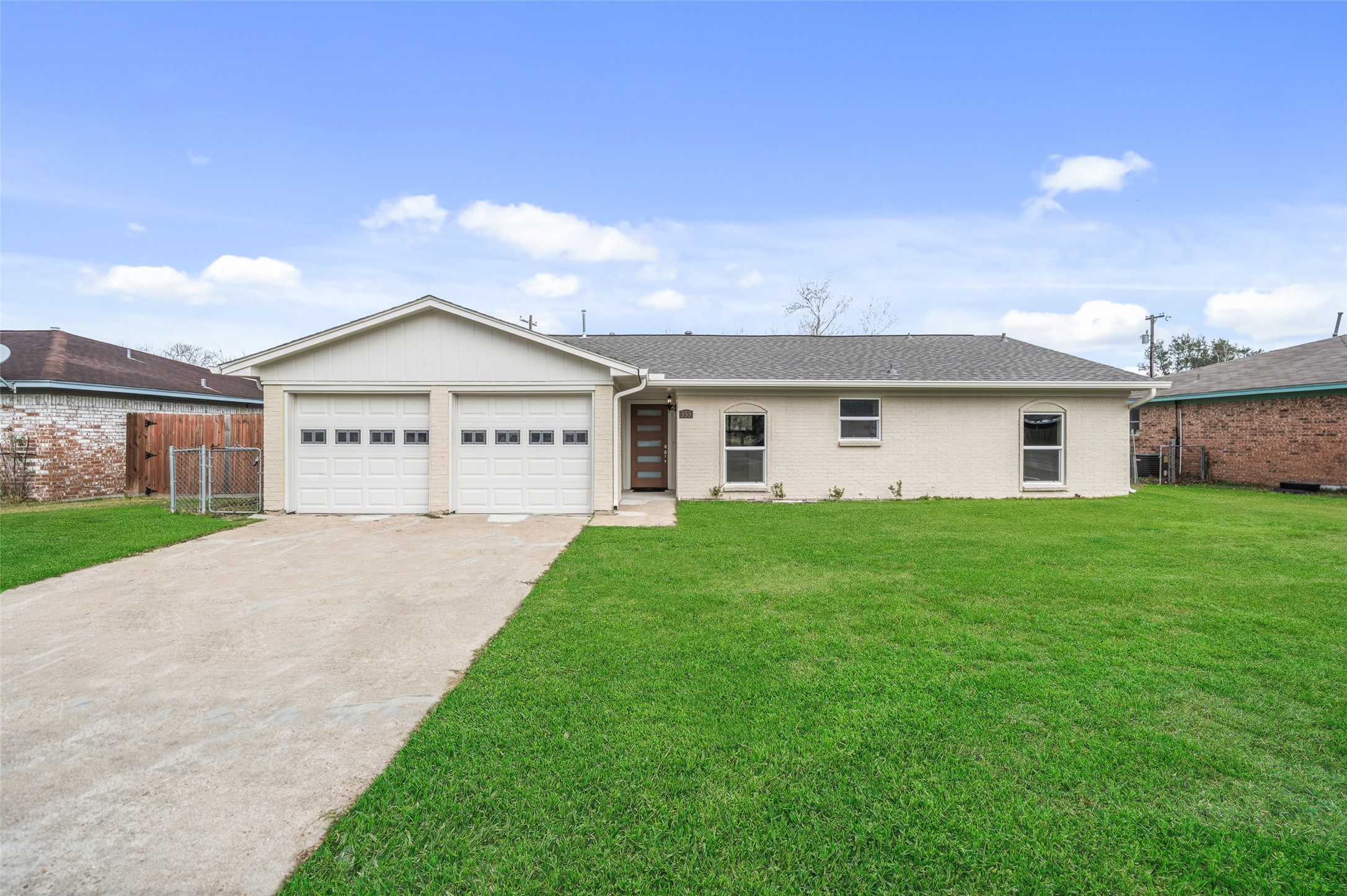 This is a single-story home with a two-car garage and a well-maintained lawn. The exterior is painted in a light color, and the house features a simple, classic design with a gable roof.